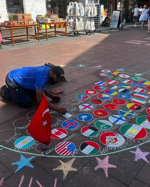 Uliczny artysta maluje kredą mapę świata
